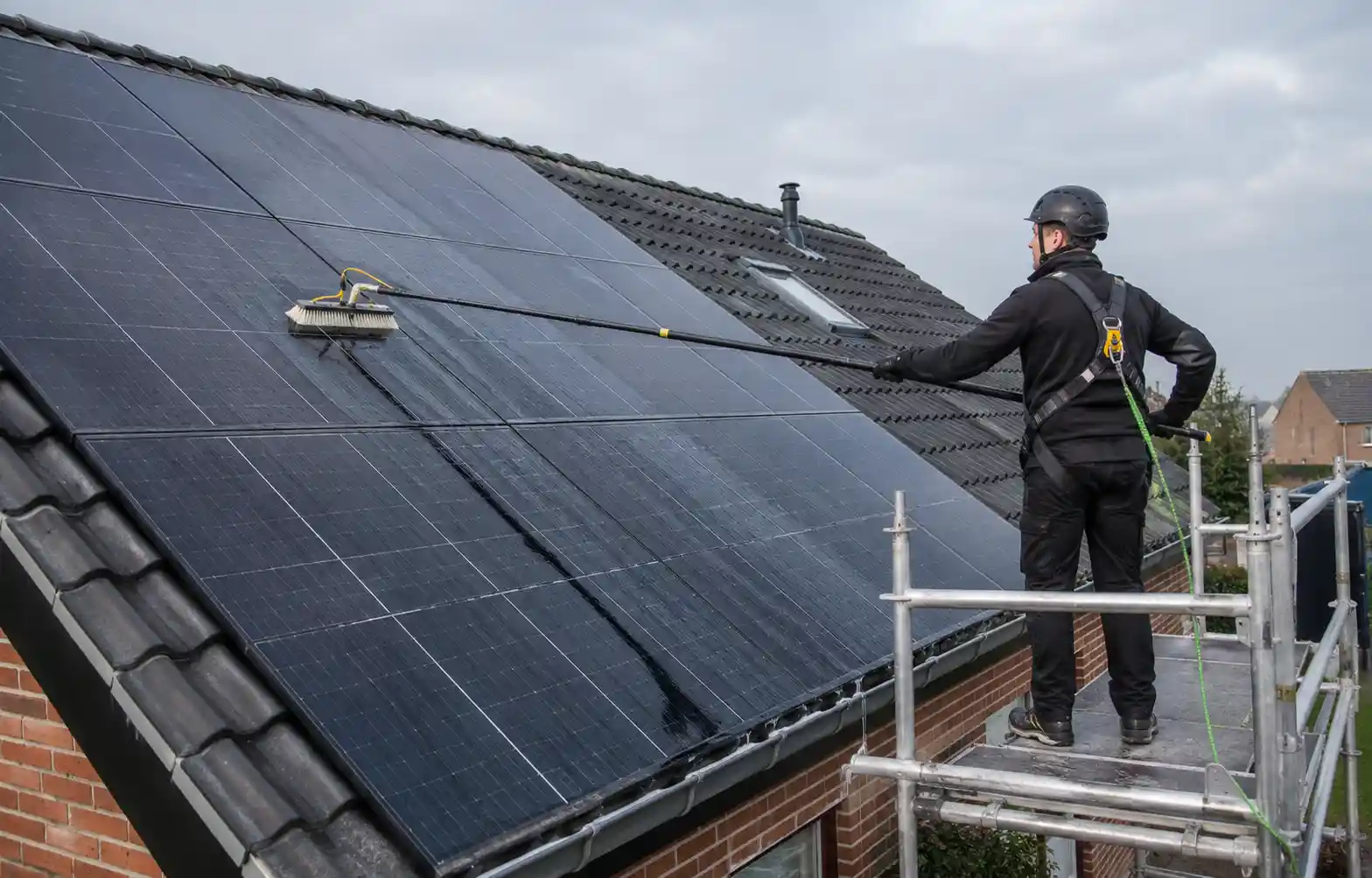 Nettoyage des panneaux solaires avec une brosse douce depuis un échafaudage